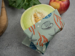 Honeywrap - Reusable Food Wrap. Ocean in Large or Extra Large Covering a Green Melon.